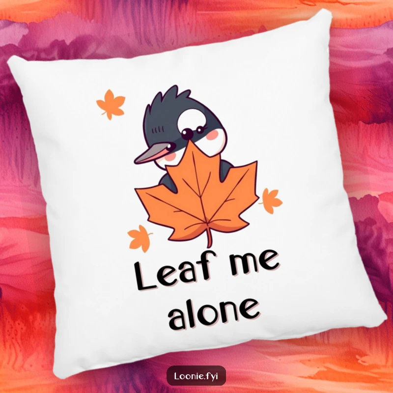 Funny throw pillow featuring a curious loon peeking behind a maple leaf, offering whimsical comfort and woodland charm.